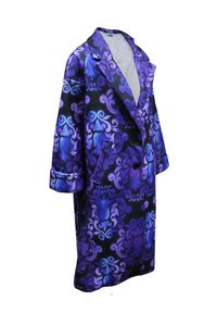 Abrigo largo con estampado en morado y negro que presenta remolinos ornamentados, dos botones y bolsillos laterales. Está hecho de un material brillante con textura suave.