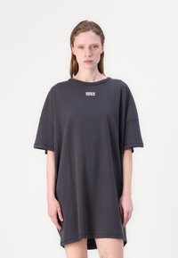 Oversized grå kjole laget av myk bomull, med korte ermer og ribbestrikket halslinning, med en liten trykt logo på brystet.