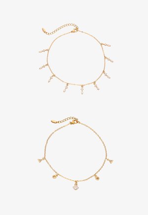 Dwie delikatne bransoletki z złotego łańcuszka, jedna z małymi, zwisającymi kryształowymi klastrami, druga z geometrycznymi i sercowatymi zawieszkami.