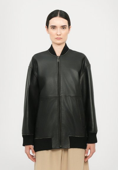 Czarna skórzana kurtka bombowca z zapięciem na zamek z przodu, ściągaczami na mankietach i gładką fakturą. Posiada dwie boczne kieszenie oraz minimalistyczny design.