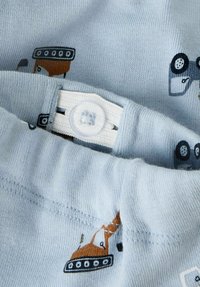 Svijetloplava tkanina s malim otiscima građevinskih vozila i bijelom podesivom kopčom na pojasu odjeće.