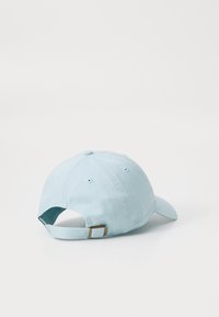 Căciulă de baseball din bumbac de culoare bleu deschis, cu bor mai curbat, curea ajustabilă și închidere metalică. Prezintă șase orificii de ventilație pentru o mai bună respirabilitate.