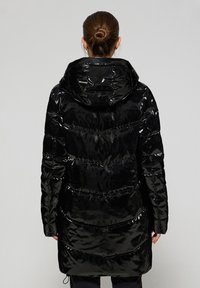 Svart glänsande puffjacka med huva, med horisontella sömmar och en åtdragen midjedetalj. Slät, glänsande yta och knä-lång design.