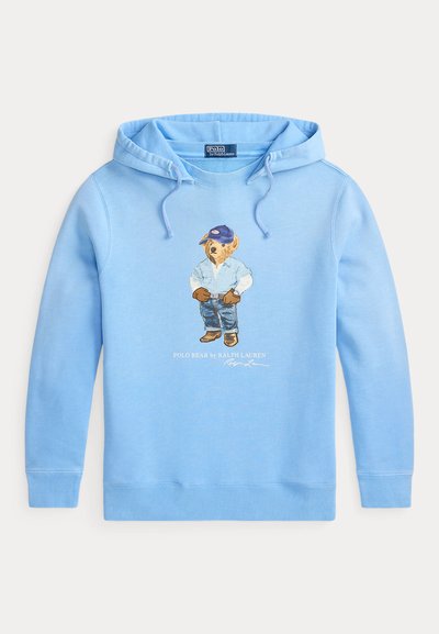 Svijetloplavi hoodie s medvjedićem koji nosi plavu kapu, traper košulju, rukavice, traperice i čizme, s natpisom "Polo Bear by Ralph Lauren" ispod.