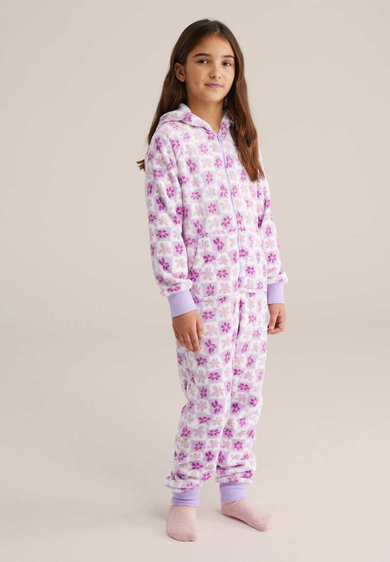 Fehér polár egyberuha lila virágmintákkal, kapucnival, elöl cipzárral és bordázott mandzsettákkal. Kényelmes viseletre alkalmas.