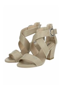 Scarpe con tacco alto beige con design a cinturino incrociato, materiale in pelle liscia, dettagli con fibbia e un tacco quadrato con texture.