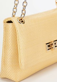 Yellow woven handbag with a smooth texture, a gold chain strap, and a metallic clasp featuring rectangular accents.