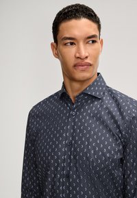 Camicia con bottoni in tessuto grigio scuro con un delicato motivo di forme azzurre. Presenta un colletto classico e maniche lunghe.