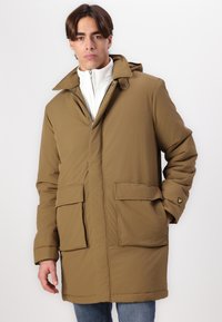 Khaki parka met een capuchon, twee voorkruiszakken en een ritssluiting; gemaakt van gladde stof; heeft een logo-accent op de mouw.