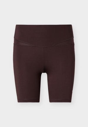Tmavě hnědé biker šortky s vysokým pasem a hladkými švy, sahající po kolena, zobrazené na světle šedém pozadí.