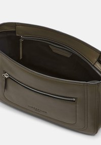 Olivgrüne Lederhandtasche mit glatter Textur, ausgestattet mit einem Reißverschluss und einer Außentasche mit Reißverschluss. Das Innere weist eine dunkle Innenauskleidung auf.