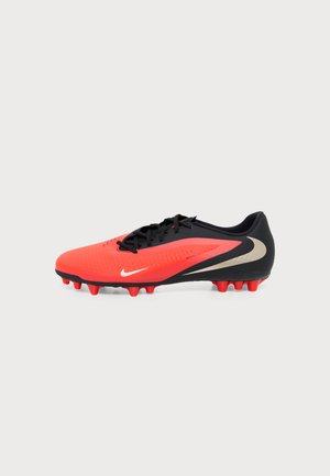 Κόκκινο και μαύρο ποδοσφαιρικό παπούτσι Nike με μαύρα κορδόνια, πολύ ακιδωτή σόλα και λευκό λογότυπο Swoosh σε απλό ανοιχτό φόντο.