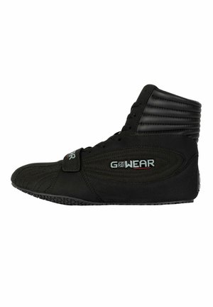 Black high-top athletic shoe with textured fabric, flexible sole, lace-up front, and an adjustable strap. Features ribbed accents and logo.