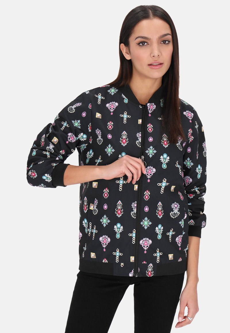 Jachetă bomber neagră cu un model floral vibrant și detalii strălucitoare. Manșete și talie cu nervuri, cu un sistem de închidere frontal cu fermoar. Material ușor.