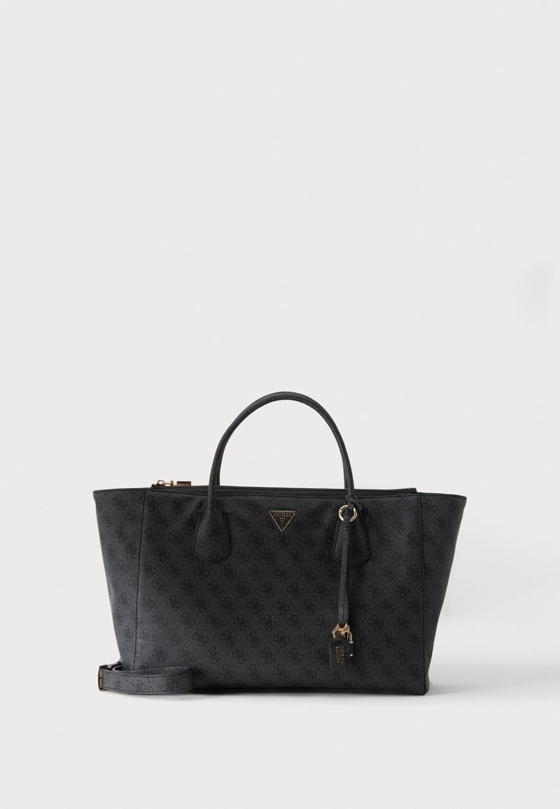 Μαύρη τσάντα Guess με διπλές λαβές, διακριτικό λογότυπο, χρυσό γούρι και αποσπώμενο λουράκι ώμου σε λευκό φόντο.