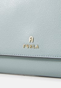 Lichtblauwe, textuurlederen portemonnee met gouden "Furla"-logo en contrasterende stiksels. Compact ontwerp met een strakke, minimalistische uitstraling.