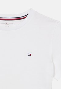 Λευκό βαμβακερό T-shirt με στρογγυλή λαιμόκοψη, με ένα μικρό κεντημένο λογότυπο σε κόκκινο, μπλε και λευκό στο αριστερό στήθος.