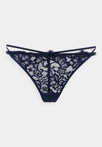 String en dentelle marine avec motifs floraux, mélange de maille douce et de tissu solide. Il présente des bretelles fines et un détail de nœud central.