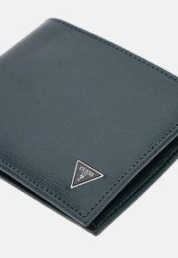 Green textured leather wallet with a silver triangle logo; features a bifold design and visible stitching along the edges.