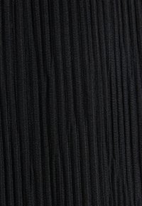 Black textured fabric featuring vertical ribbing, creating a subtle pattern with a soft, slightly raised surface.