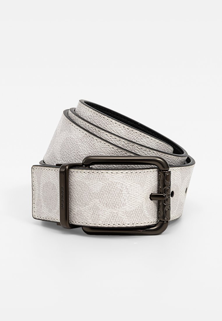 Ceinture en tissu blanc avec un motif texturé, dotée d'une boucle en métal foncé et d'accents de couture. Dessous lisse, longueur ajustable standard.