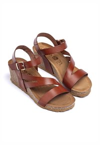 Sandali wedge in pelle marrone con cinturini diagonali, fibbia regolabile e soletta in sughero testurizzato con suola in gomma decorata.