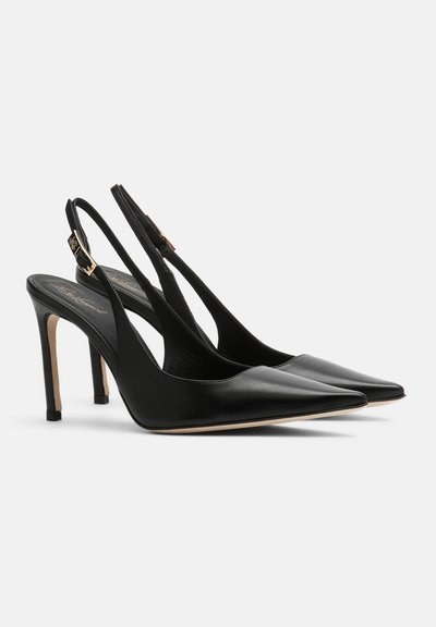 Sorte læder slingback høje hæle med spidse tæer, tynde stilethæle og guldbeslag på stropperne.