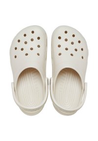 White clogs with perforated top for ventilation. Rounded design, textured sole patterns, and back strap for secure fit. Made of lightweight material.