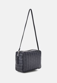 Borsa a tracolla nera con motivo geometrico, di forma rettangolare, superficie testurizzata e tracolla regolabile. Presenta una chiusura con zip e hardware con logo.