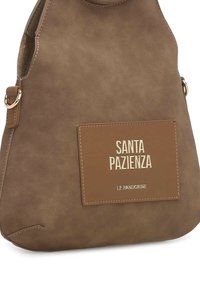 Borsa a mano in camoscio marrone con una texture distintiva, caratterizzata da una patch con logo in rilievo dorato con la scritta "SANTA PAZIENZA" e dettagli beige a contrasto.