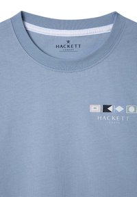 Camiseta de algodón azul claro con cuello redondo y un logotipo geométrico en varios colores. Textura suave con un corte estándar.
