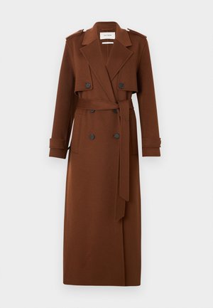 Longue trench-coat brun à double boutonnage avec de larges revers, taille ceinturée, épaulettes boutonnées et bracelets aux poignets.