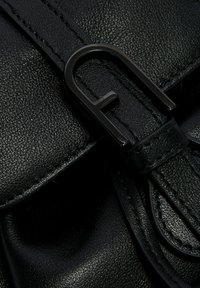 Borsa a mano in pelle nera con finitura texture. Presenta una chiusura in metallo nero audace e dalla forma distintiva, che completi il design elegante.