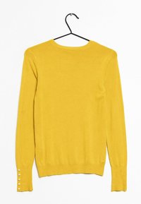 Gelber langärmeliger Pullover mit Rundhalsausschnitt und geripptem Saum, der dekorative Knöpfe an den Bündchen und eine glatte Textur aufweist.