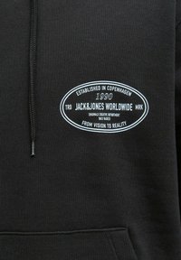 Sudadera negra con logo ovalado blanco que dice "Establecido en Copenhague 1990 Jack & Jones Worldwide Originals Creative Department Daily Basics."