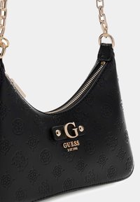 Czarna torba na ramię z ekoskóry z tłoczonym wzorem, złotymi elementami i zapięciem na zamek. Na przedniej stronie znajduje się akcent z logo.