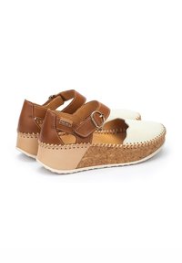 Sandalias de cuero marrón y crema con suelas de corcho en cuña, correa ajustable con hebilla de metal y costura decorativa a lo largo de los bordes.