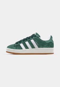 Sneaker Adidas Campus in camoscio verde con strisce bianche, lacci neri, suola bianca e suola esterna in gomma, mostrata di profilo laterale.