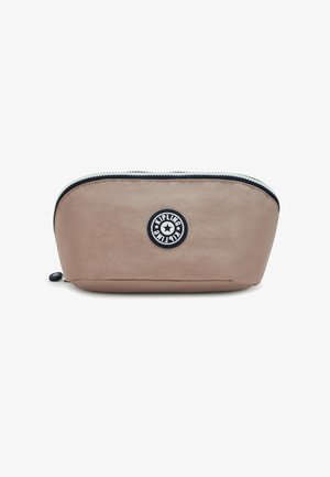 Pochette cosmétique en nylon beige avec un design incurvé, fermeture éclair sur le dessus et un patch logo circulaire à l'avant. Texture lisse et format portable.