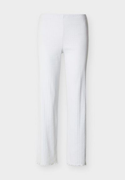 Λευκό ριμπ παντελόνι με ίσια γραμμή και ψηλή μέση, με μικρή λεπτομέρεια βολάν στην τελική ραφή, παρουσιάζεται επίπεδο σε ανοιχτό φόντο.