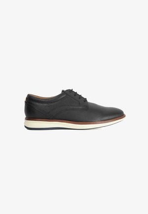 Black leather shoe with a rounded toe, textured surface, lace-up design, white midsole, and brown accent around the sole.