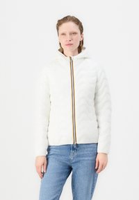 Giacca imbottita bianca con cappuccio, caratterizzata da una texture ondulata e un accento di zip multicolore. Abbinata a jeans blu.