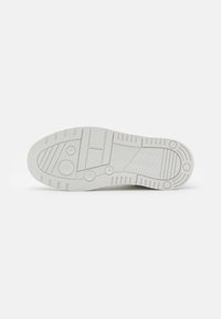 Suola di sneaker bianca con motivi testurizzati, accenti circolari e caratteristiche di presa. Realizzata in gomma, presenta una finitura liscia e un design resistente.