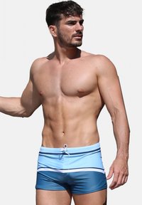 Shorts de bain bleus au design ajusté, avec un dégradé de bleu clair à bleu foncé, des rayures horizontales blanches et une taille à cordon.