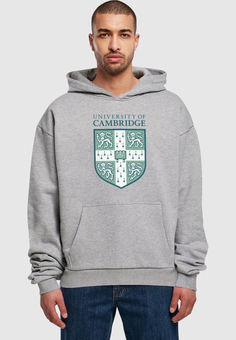 Šedá mikina s kapucňou so znakom Univerzity v Cambridge v zelenej a bielej farbe, s klokankou a rebrovanými manžetami.