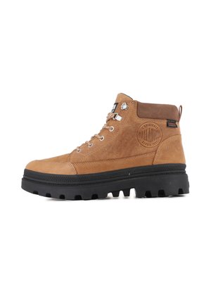 Brown leather ankle boot with a black rubber sole, metal eyelets, and a padded collar. Features embossed logo detail on the side.