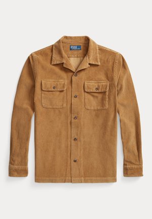 Brown corduroy shirt with a collared neckline, two chest pockets, button-down front, and long sleeves. Visible texture and ribbed pattern.
