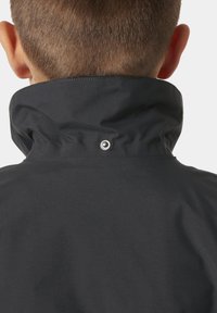 Czarna kurtka z wysokim kołnierzem, z detalem na napy. Wykonana z gładkiego materiału o matowym wykończeniu, bez widocznych wzorów.