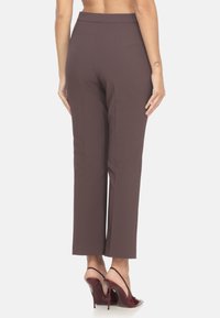 Pantaloni marroni su misura con una texture liscia e una forma dritta, caratterizzati da una vita media e un design pulito e minimale.