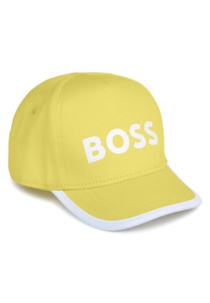 Cappello giallo con logo "BOSS" bianco. Realizzato in tessuto, presenta una visiera curvata e una bordatura bianca lungo il bordo. Design strutturato, senza motivi.